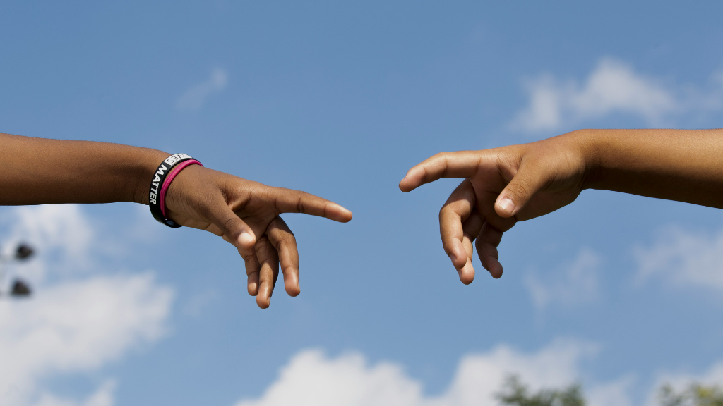 Two hands pointing towards one another
